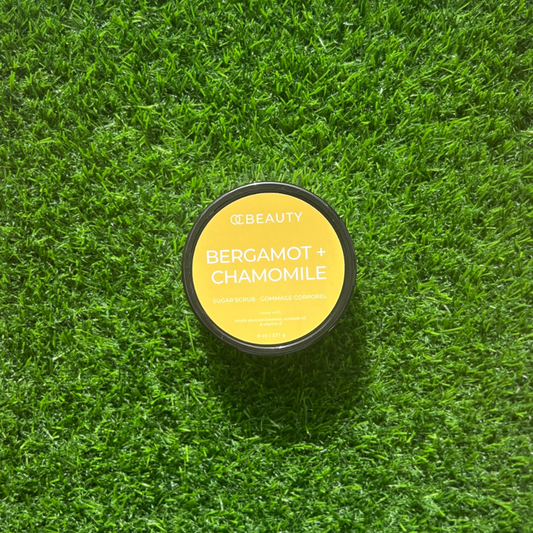 Jar of OBEAUTY Bergamot + Chamomile product on grass