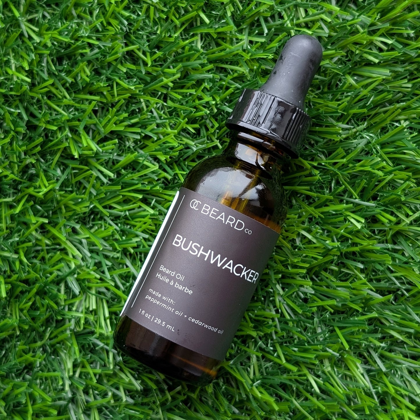 Bottle of Bushwacker Beard Oil on green grass