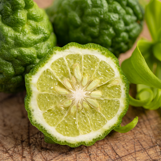 bergamot, with a sliced open one showing its interior on a wooden surface.