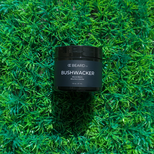 Black jar labeled 'BUSHWACKER' on a green grass background