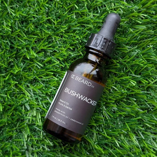 Bottle of Bushwacker Beard Oil on green grass
