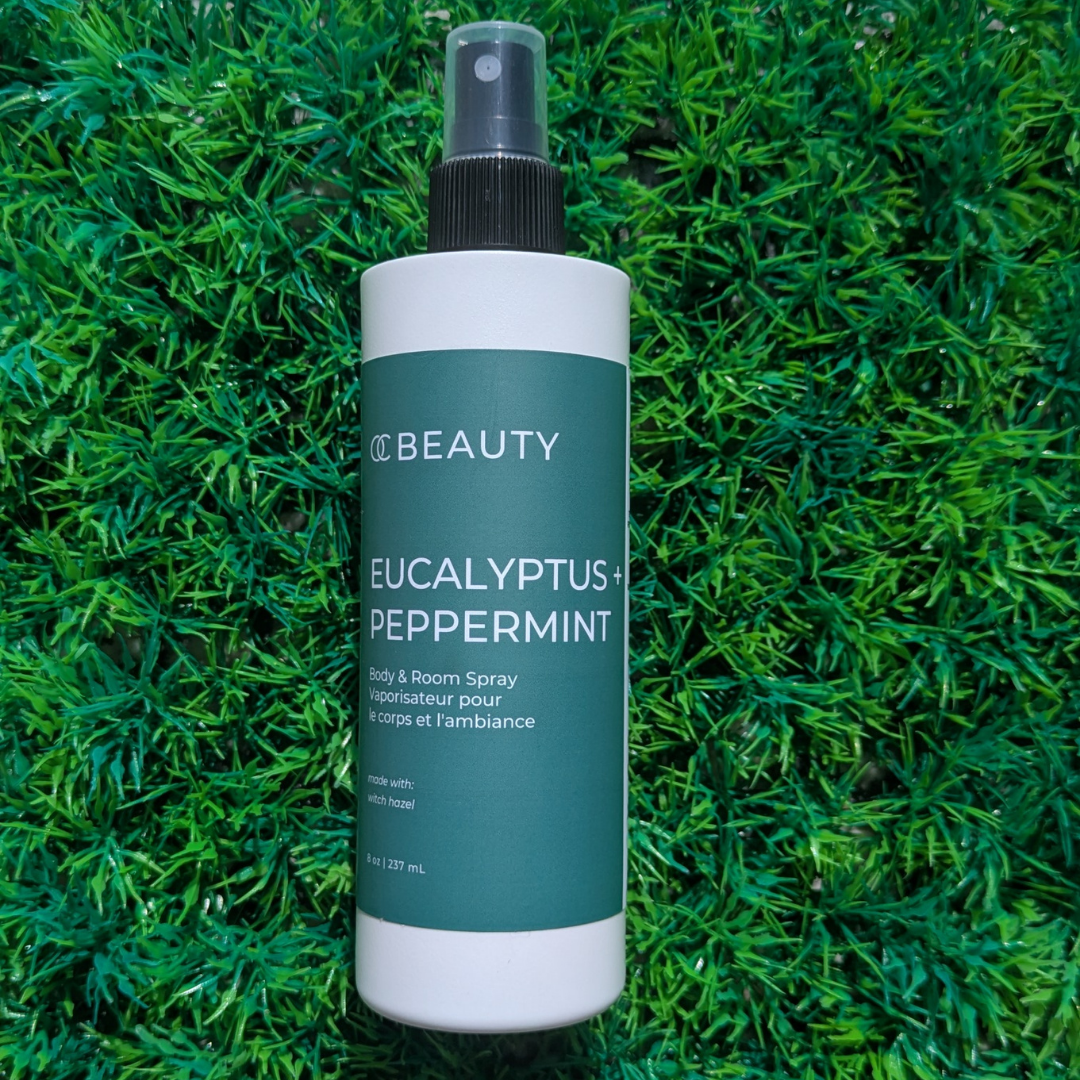 Spray bottle labeled 'Eucalyptus + Peppermint' on a green grass background